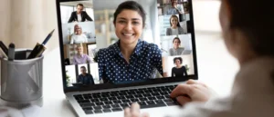 A person joins a Small Group Live Coaching (Single Session) via laptop, engaging with nine others in a video call. All appear positive and attentive, highlighting personal growth and effective coaching in the virtual meeting.